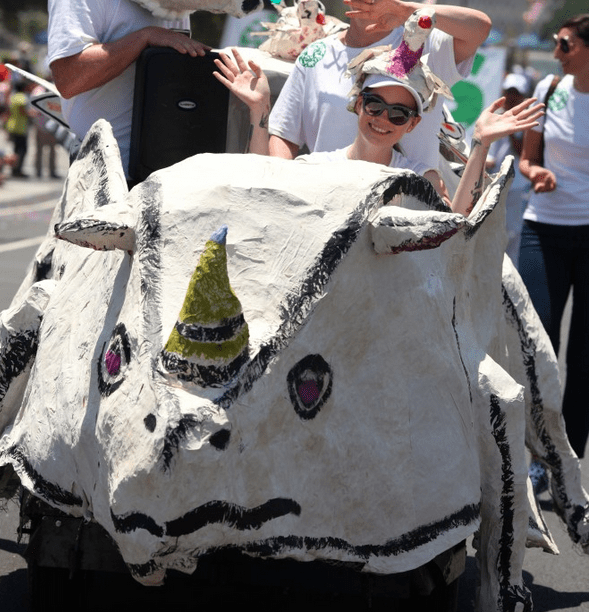 Person riding a rhino-shaped float