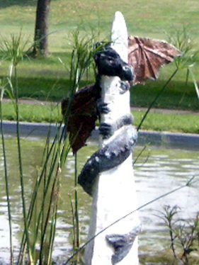 Dragon statue wrapped around white pillar.