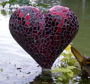 Mosaic heart sculpture in water garden.