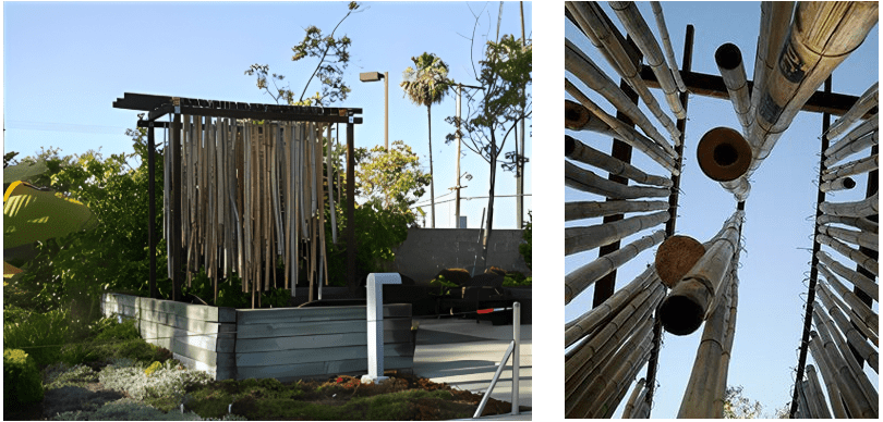 Outdoor bamboo art installation under clear sky.