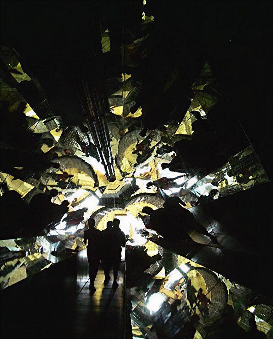 Silhouetted figures in mirrored tunnel