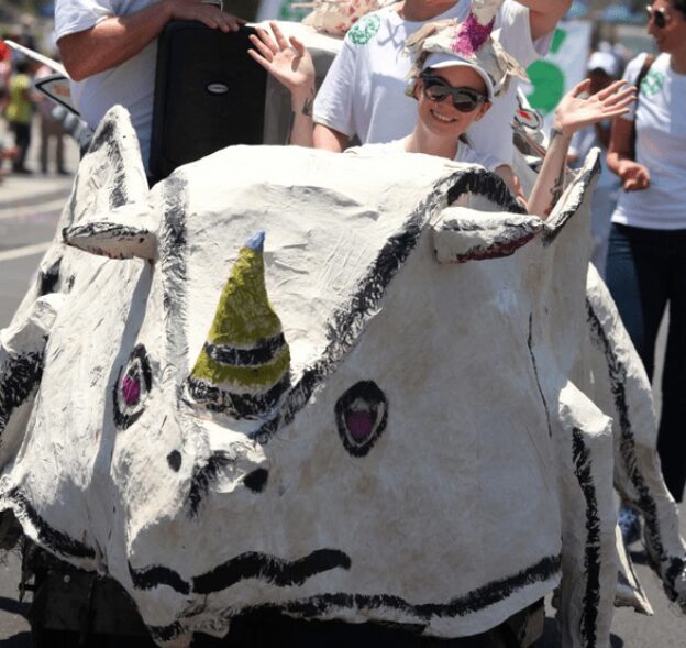 Person riding a whimsical unicorn float.