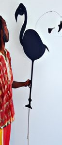 Person holding black flamingo silhouette stick.