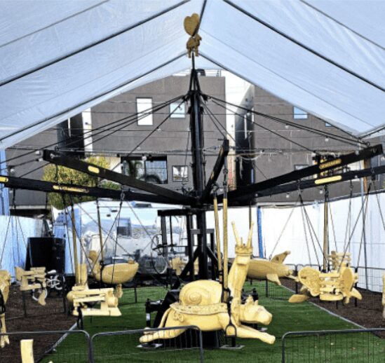 Carousel with animal-shaped seats under tent.