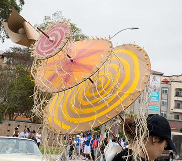 Person wearing colorful, spiral-patterned costume.