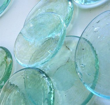 Transparent glass discs on a white surface.