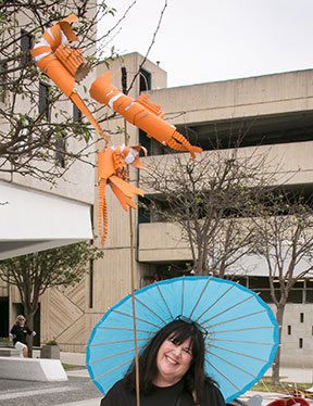 Woman with blue parasol and orange decorations.