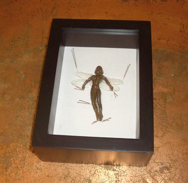 Framed sculpture of a fairy-like figure.