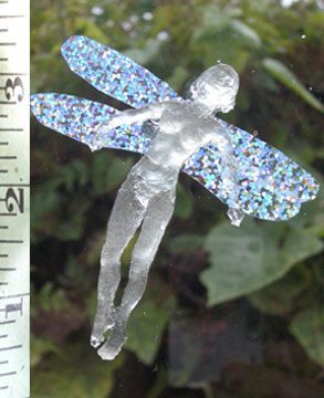 Fairy figurine with glittery wings near ruler.