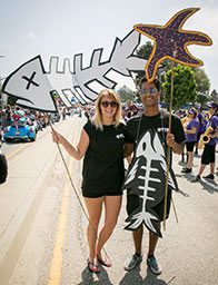 People holding fishbone and starfish signs.