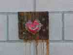 Heart graffiti on weathered brick wall.