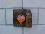 Heart-shaped artwork on textured brick wall.