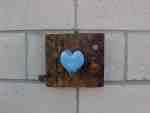 Blue heart on a wooden plaque.