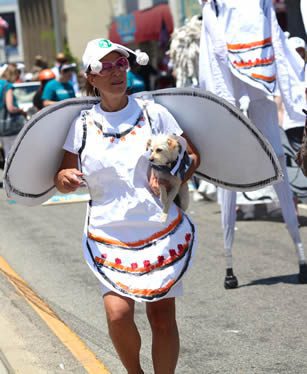 Person in costume holding a small dog.