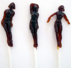 Human-shaped lollipops on white background.