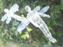 Glass figurines resembling fairies with wings.