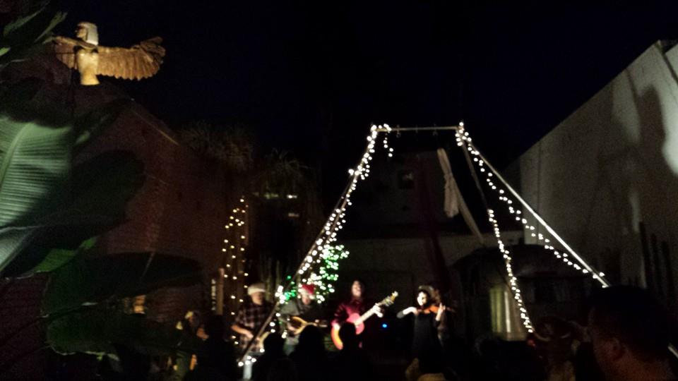 Outdoor night concert with string lights.