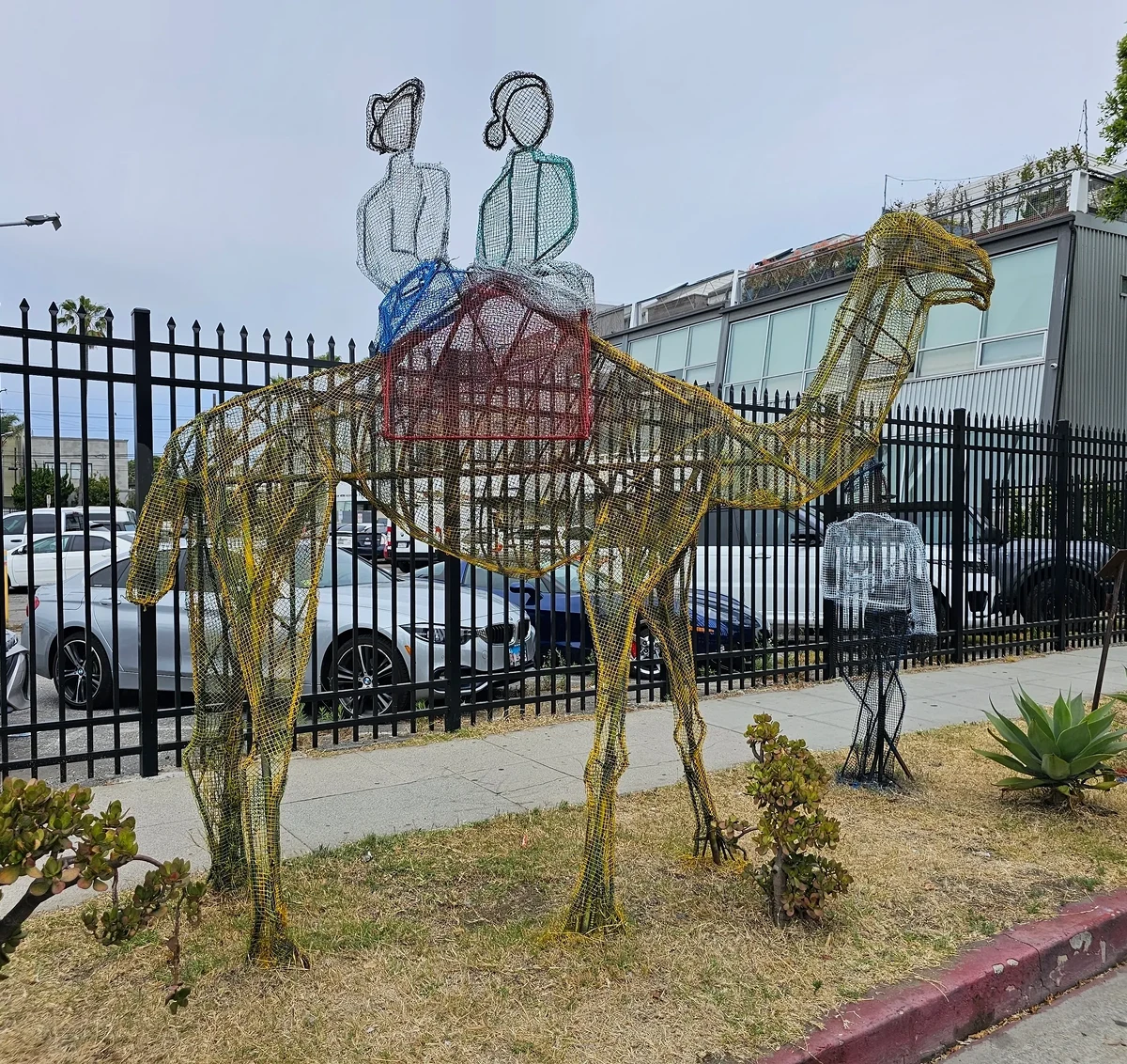 Wire camel sculpture with two riders.