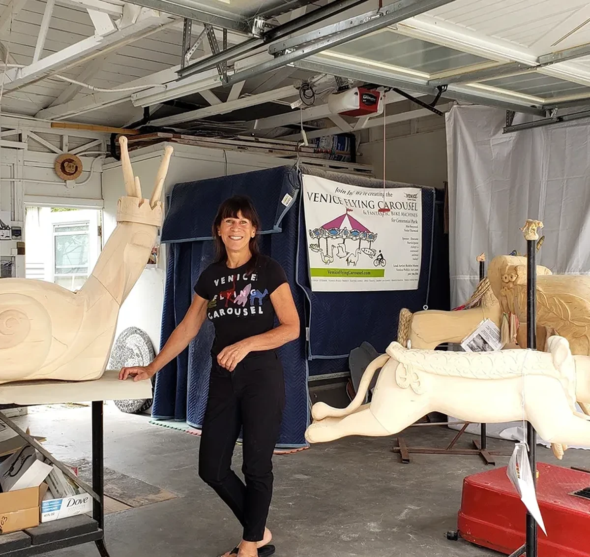 Woman in workshop with carousel animals.