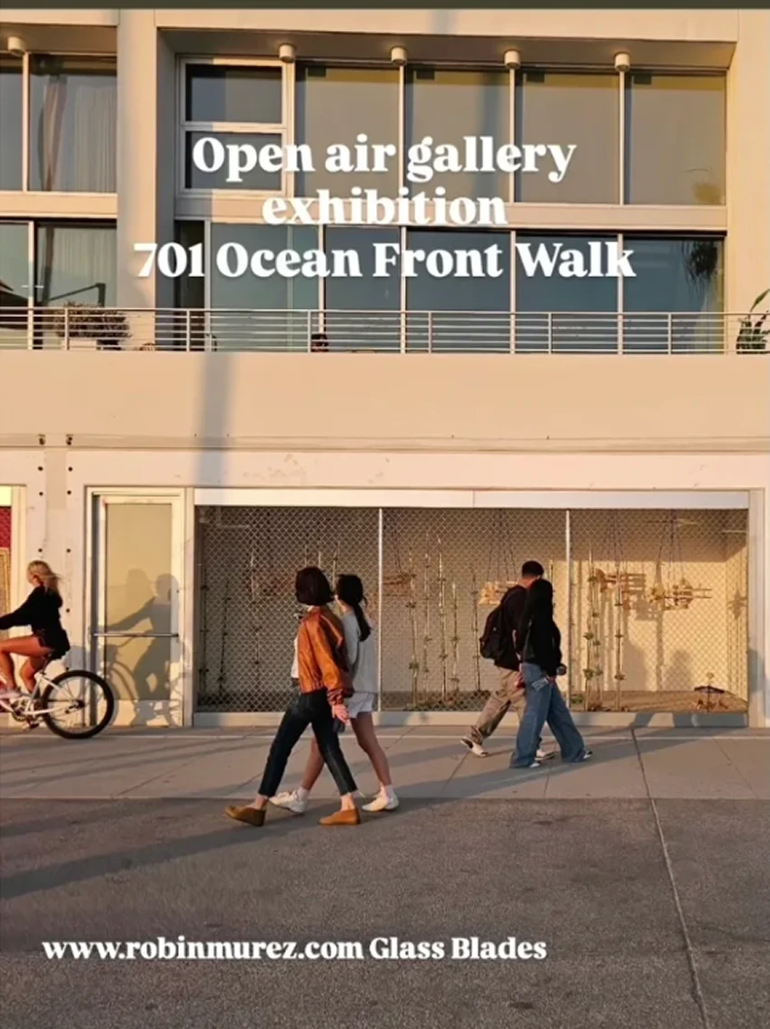People walking past an open air gallery.