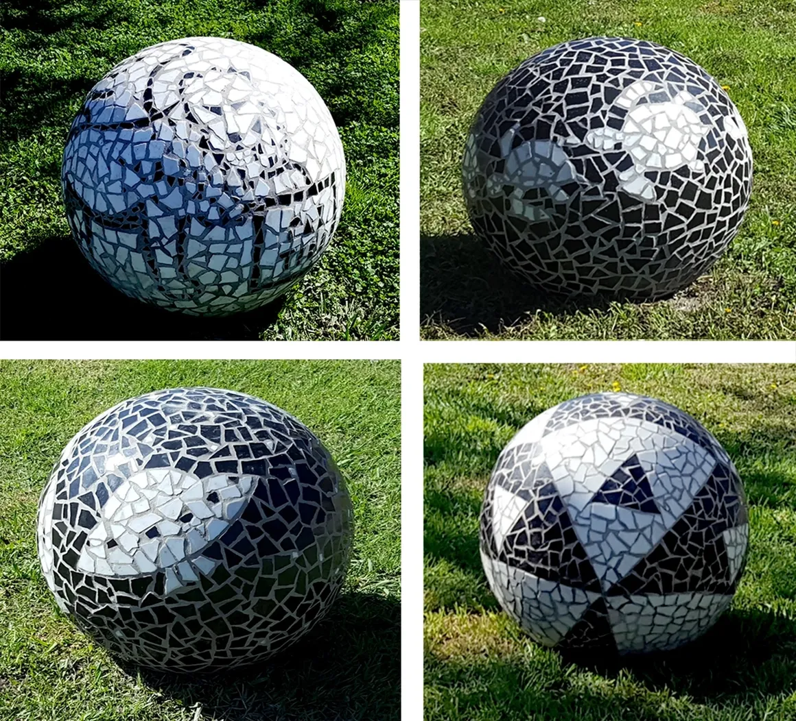 Mosaic spheres on grass in sunlight.