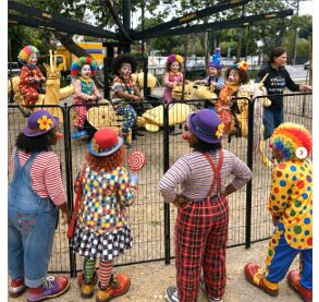 Kids dressed as clowns at fenced playground