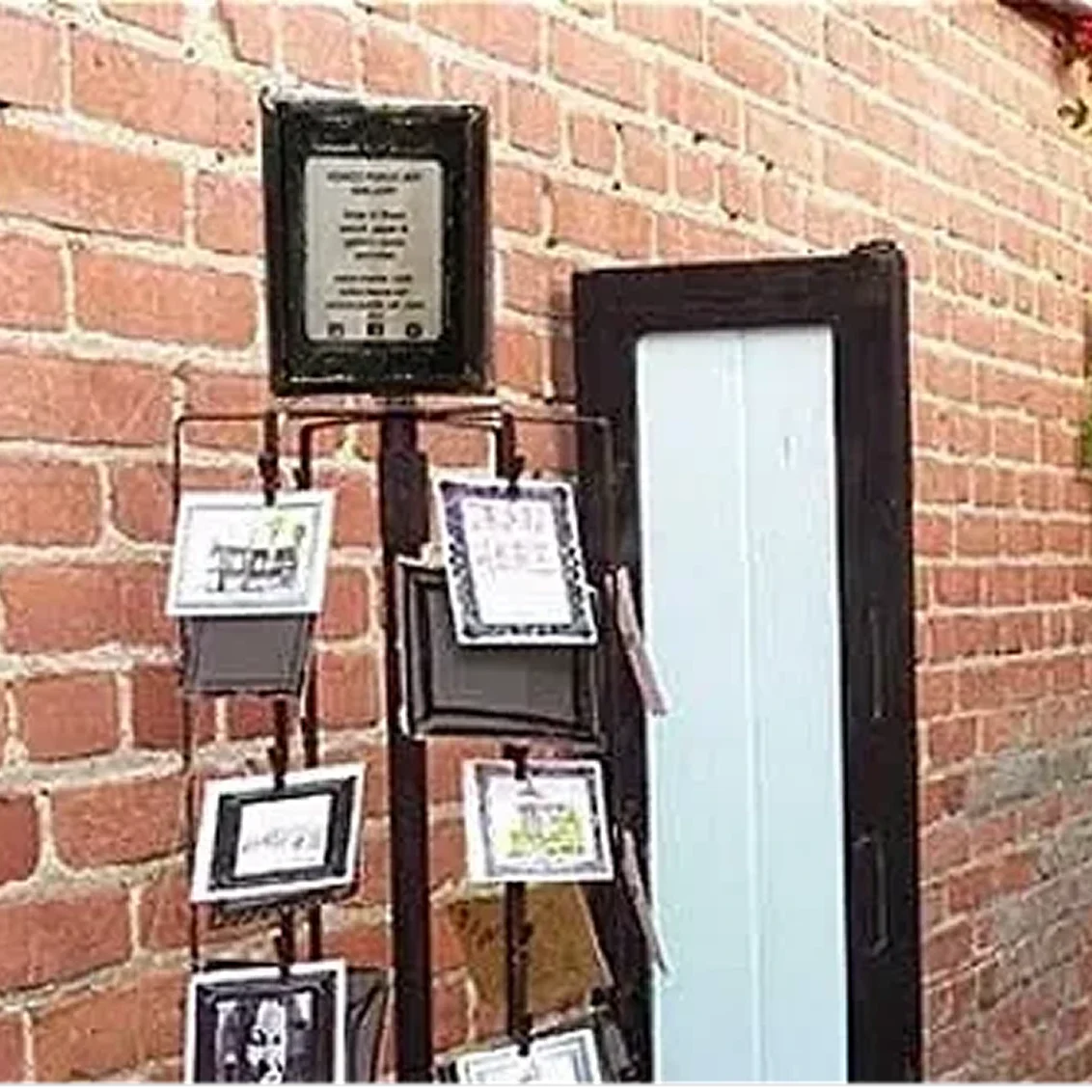Postcard stand against brick wall background.
