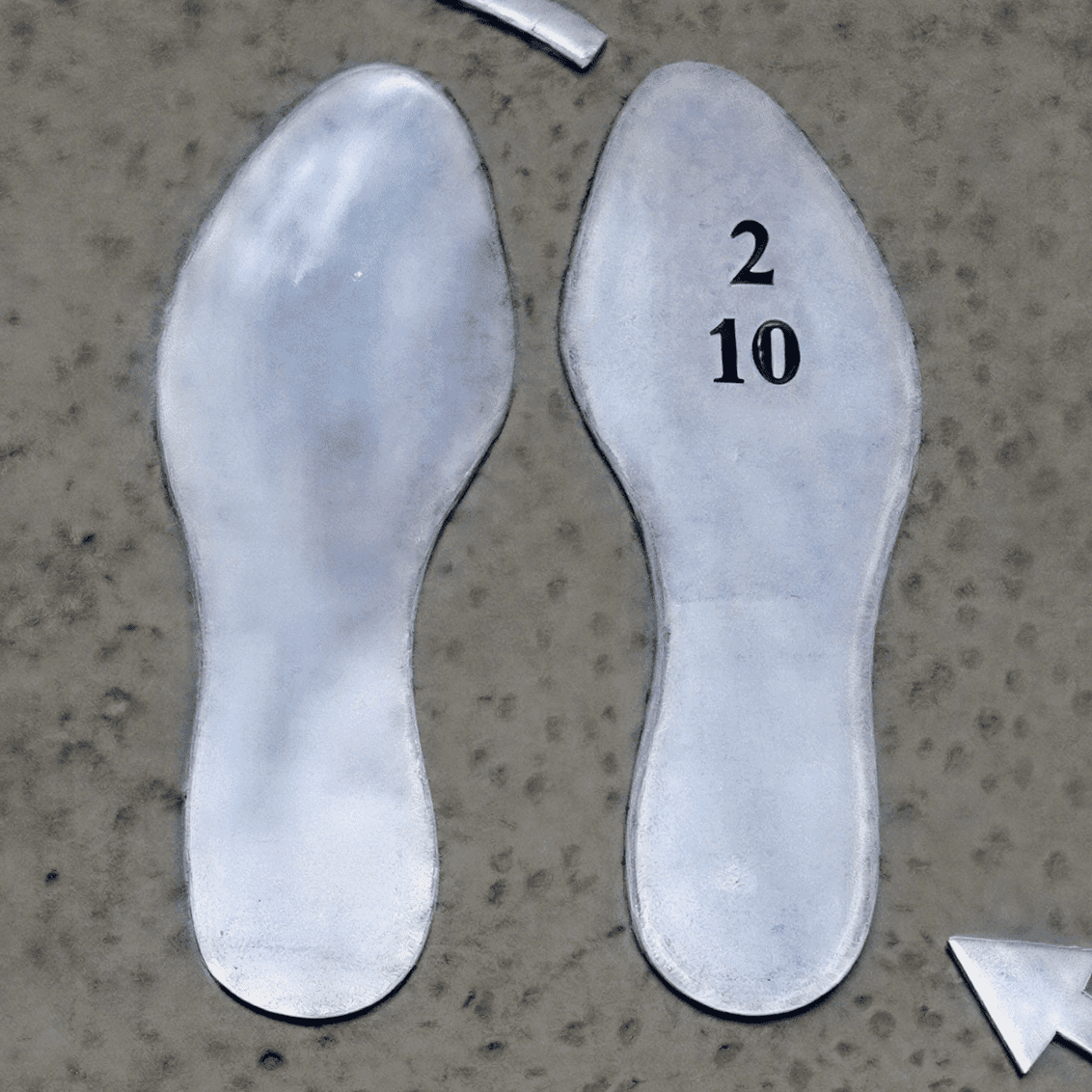 Metal shoe outlines on ground surface