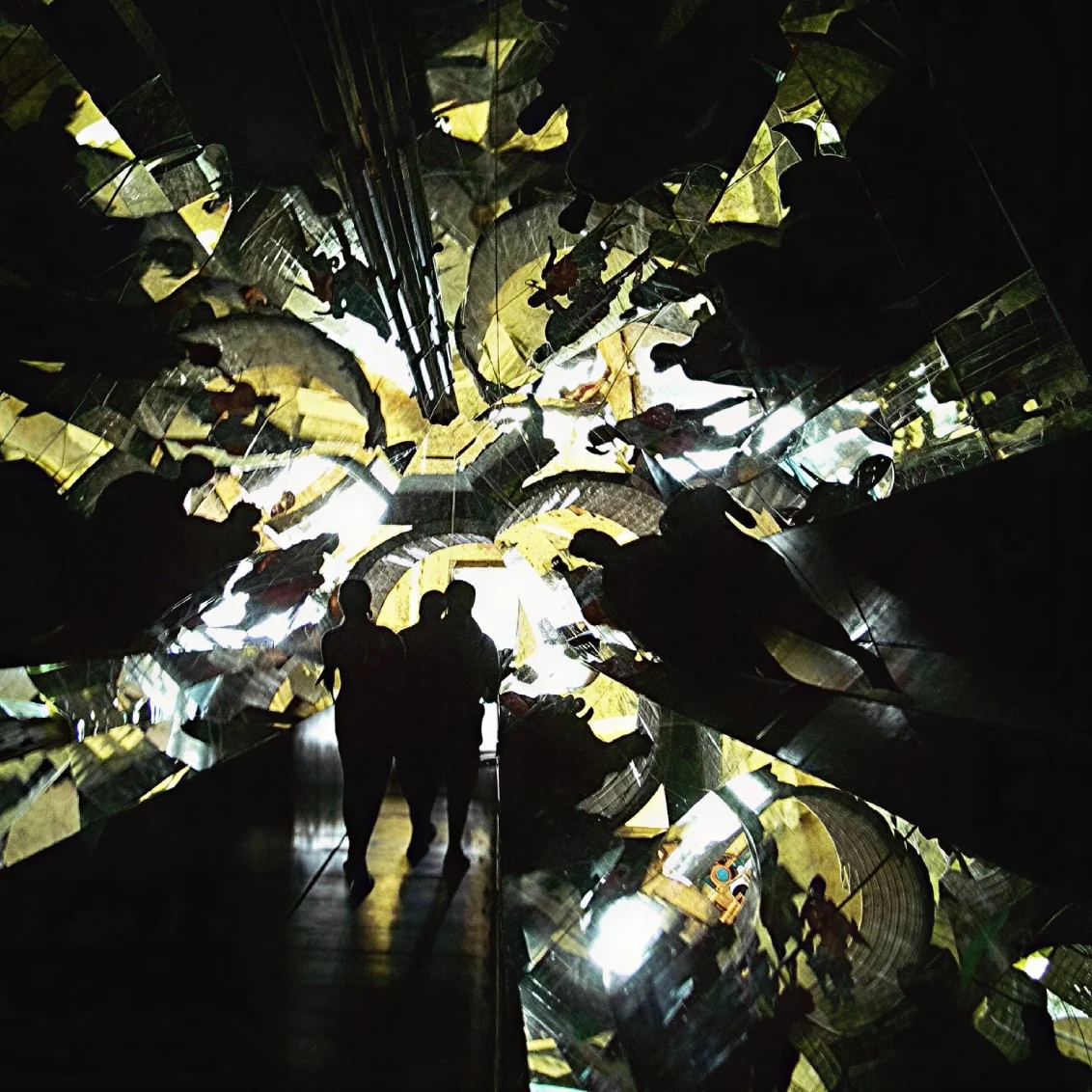Abstract mirrored reflections with silhouetted figures.