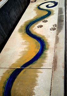 Colorful sidewalk art with animal paw prints.