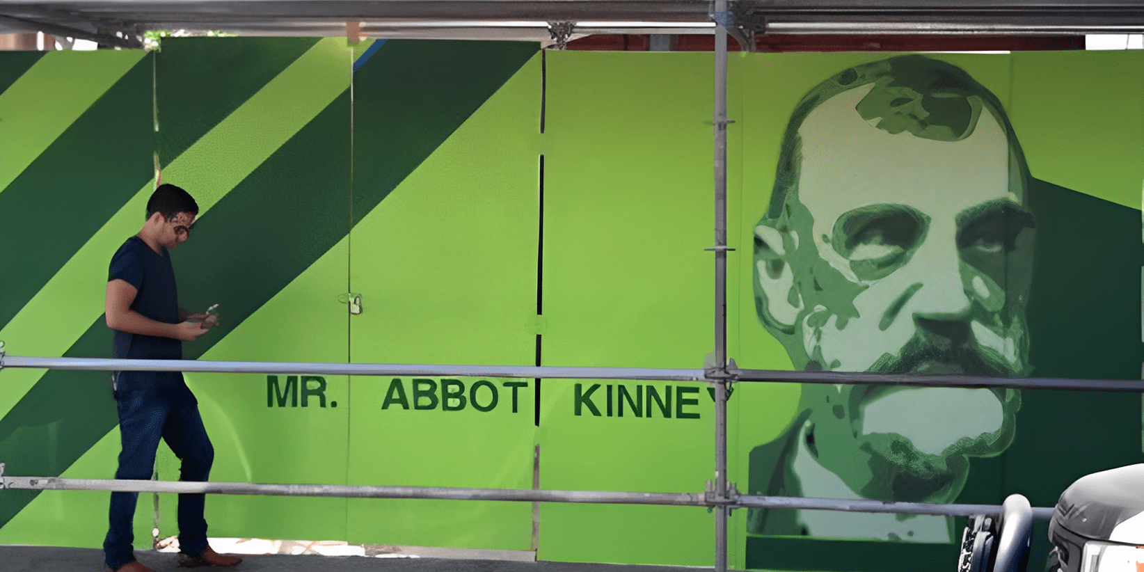 Man walking past Abbot Kinney mural